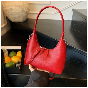Dettaglio della pelle con texture litchi rossa su una borsa a tracolla hobo a mezzaluna