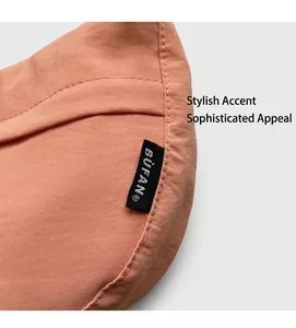 Close-up detail of coral nylon bag fabric with BUFAN woven brand label and stitching