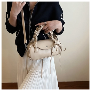 Detailansicht der cremefarbenen Zylindertasche mit Rüschengriff und Schleifendetail