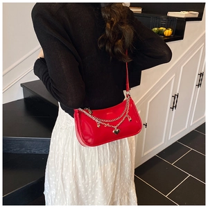 Model view of red patent leather shoulder bag with silver chain heart charms