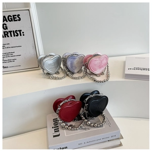 Mini heart-shaped chain bags in five colors displayed on a modern white step stand