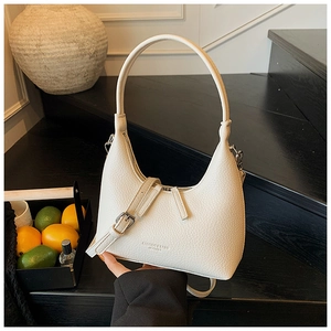 Dettaglio borsa beige in pelle martellata con fibbie metalliche e tracolla regolabile