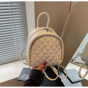 Detailed view of quilted faux leather backpack with sparkling rhinestone embellishments