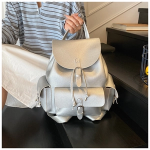 Silver textured leather backpack featuring multiple pockets and drawstring closure detail