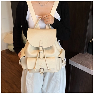 Detail of off-white leather backpack with lychee texture and metallic buckle pocket