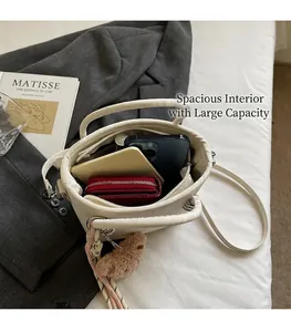 White leather bucket bag showing internal storage space for phone, wallet and cards