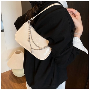 Detail of cream glossy baguette bag with double silver chains and lock pendant detail