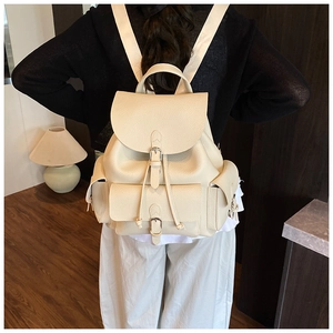 Detailed view of cream pebble leather backpack with vintage buckle and fabric straps