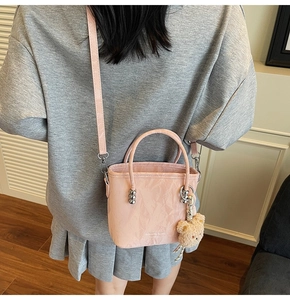 Borsa a secchiello plissettata rosa con ciondolo a orsetto vista a spalla lifestyle