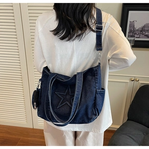 Detail der blauen Denim-Tasche mit Sternsteppung und verstellbarem Schultergurt