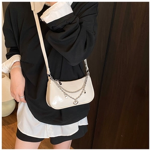 Detail view of cream white shiny PU leather shoulder bag with silver heart chain charms