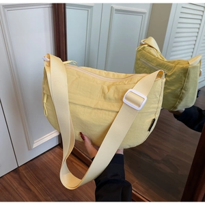 Detail view showing light yellow nylon crescent bag with adjustable strap and buckle