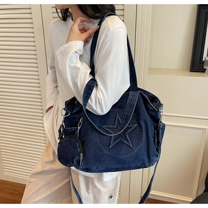 Detail der Denim-Tote-Bag mit Sternsteppung, breitem Schultergurt und kleiner Geldbörse
