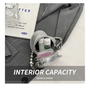 Detail showing the internal capacity of the silver heart-shaped mini crossbody bag