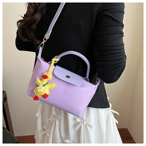 Detail of light purple nylon and leather crossbody bag with a cute duck pendant