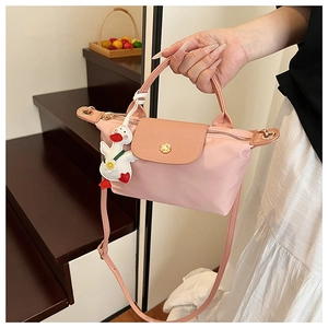 Detail of pink mini nylon tote with leather flap and cute white duck charm