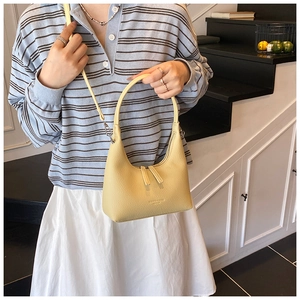 Dettaglio della borsa hobo giallo pallido in pelle litchi con tracolla regolabile e fibbie