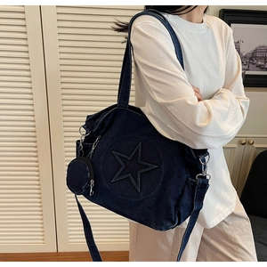 Détail d'un sac cabas en denim bleu avec étoile en relief et petit porte-monnaie rond