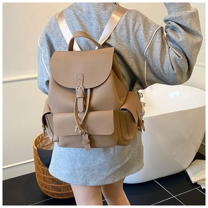 Detail of khaki leather backpack with flap magnetic buckle and textured lychee pattern
