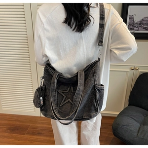 Détail du sac cabas en denim délavé avec patch étoile et bandoulière amovible