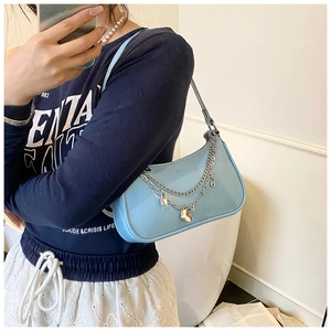 Detail of light blue patent leather bag with silver chains and heart lock pendant