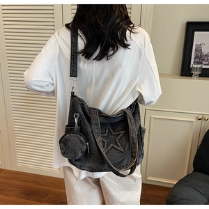 Detail der großen schwarzen Denim-Sterntasche mit verstellbarem Gurt und Mini-Geldbörse