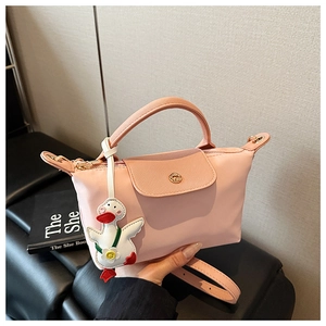 Detail of pink nylon handbag with synthetic leather flap and cute white duck charm