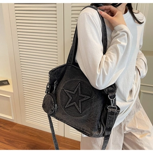 Détail du sac cabas en denim noir avec gaufrage étoile et mini porte-monnaie rond attaché