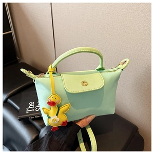 Detail of mint green mini square bag with pebble texture and yellow duck charm