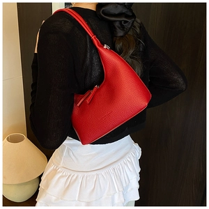 Borsa hobo in pelle rossa con grana litchi e logo in rilievo portata a spalla da modella
