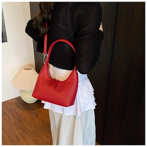 Vista laterale della borsa a mezzaluna rossa motivo litchi indossata da una modella