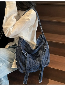 Stylish oversized washed denim tote bag with frayed edges and decorative ribbons