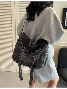 Large distressed denim crossbody bag in dark washed blue with adjustable shoulder strap