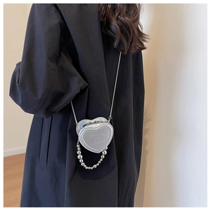 Silver heart-shaped mini crossbody bag with metal chain strap and pearl handle detail
