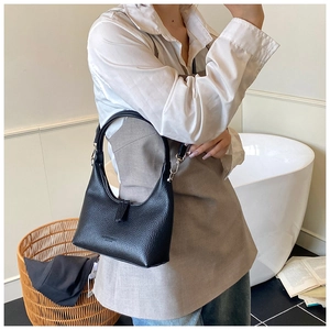Dettaglio borsa hobo nera con trama a litchi e fibbia in metallo argento sulla tracolla