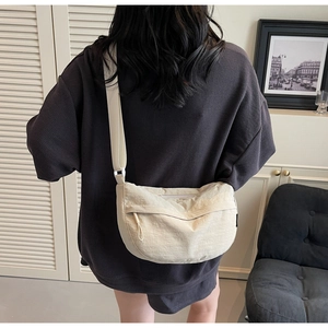 Detail of beige nylon crescent bag featuring adjustable wide strap and waterproof texture