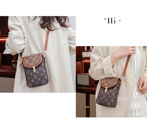 Detail of vintage patterned crossbody phone bag with gold metal buckle and adjustable strap