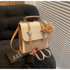 Detail of cream and beige PU leather backpack with silver star buckles and bear charm