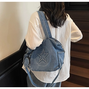 Sac cabas en jean bleu avec patch étoile et petite pochette porté par un mannequin