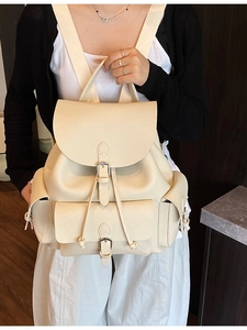 Chic beige lychee leather backpack with flap closure and wide shoulder straps on model