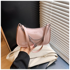 Detail of pink patent leather handbag with silver heart chain and logo embossing