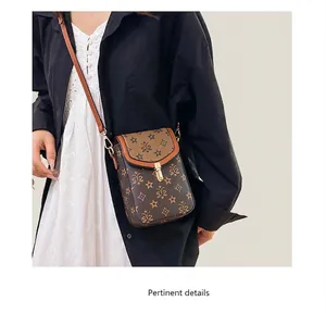 Detailed view of a vintage monogram crossbody phone bag with gold clasp and leather strap