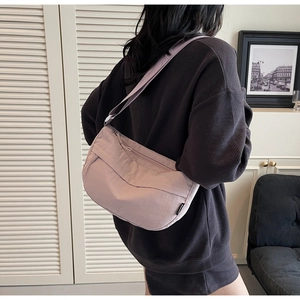Detail view of a light purple nylon crescent bag with textured fabric and BUFA logo label
