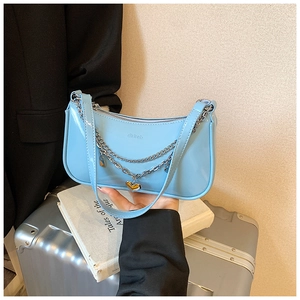 Detail of light blue patent leather bag with silver chain and heart pendant
