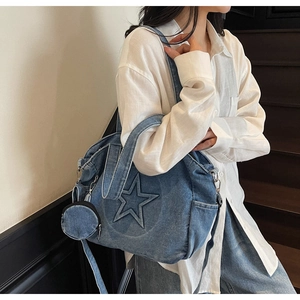 Détail du sac cabas en denim bleu avec surpiqûres étoiles et porte-monnaie rond assorti
