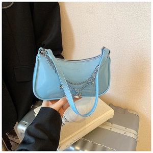 Detail of light blue patent leather bag with silver heart charm and chain handle