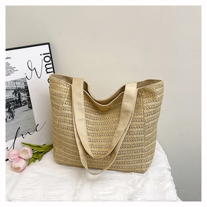 Close-up of a natural woven tote bag featuring fine straw texture and durable nylon strap