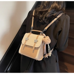 Detailed view of the contrast color mini backpack with star buckles and a plush bear charm