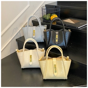 Macro detail of bucket bags in four colors with crocodile embossed texture and gold locks