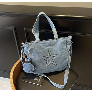 Détail du cabas en denim bleu clair avec patch étoile et mini pochette ronde assortie